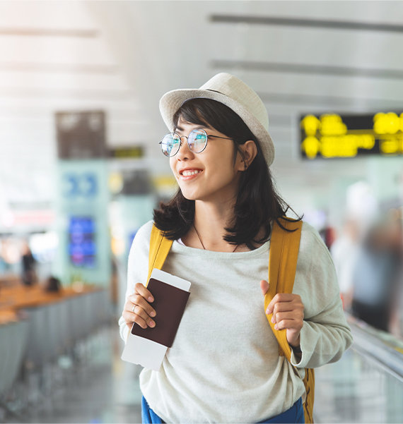 Girl walking through airport holding passport